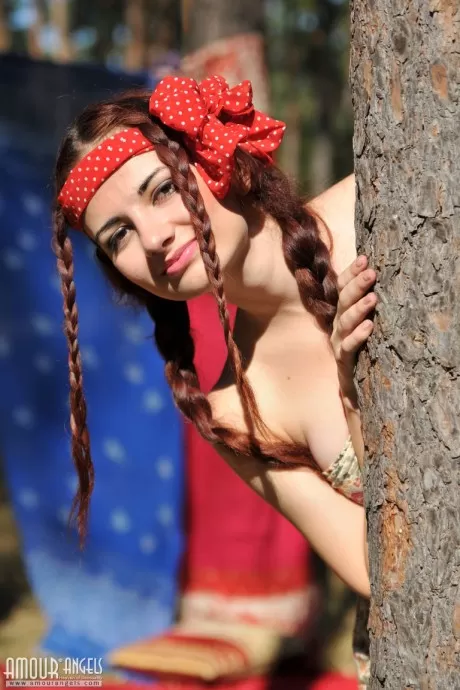 Симпатичная рыжеволосая Джулли раздевается догола в лесу, ее волосы заплетены  4