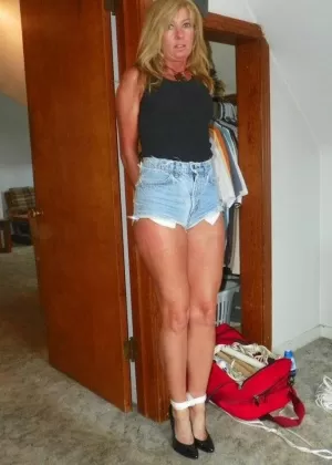 Одетая женщина с кляпом во рту связана веревкой на односпальной кровати