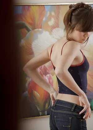 Adorable brunette babe in jeans undressing and posing on the massage table