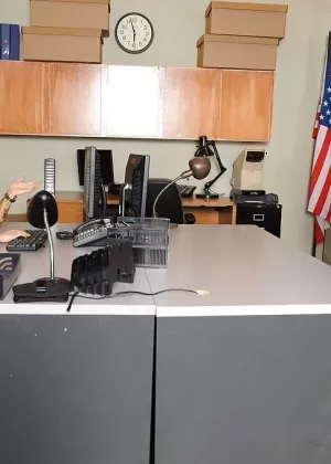 Полностью одетая женщина борется на ковровом покрытии с кляпом во рту и наручниками