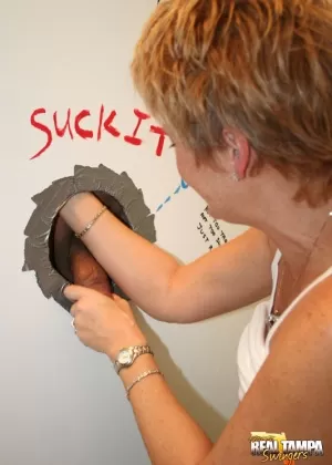 Mature redhead Tracy Lick sports short hair while sucking a BBC at a gloryhole