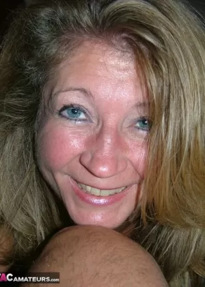 Рыжеволосая зрелая леди обнажает свои сиськи и обнажает свою пизду крупным планом