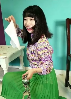 Close Asian chick removes ankle cuffs after being chained to a chair