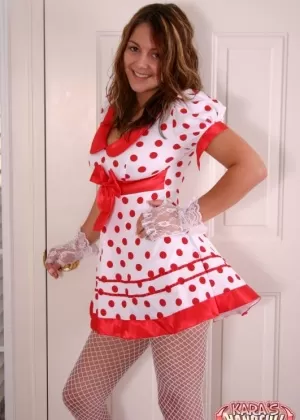 Одетая женщина демонстрирует свои туфли на шпильках в черном нижнем белье и чулках