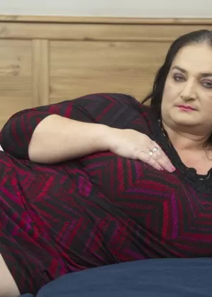 Любительская модель Горячая милфа обнажает свои сиськи на кровати в черных колготках