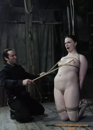 Высокий Домм в кожаных штанах принуждает мужчин и женщин-рабынь к порке
