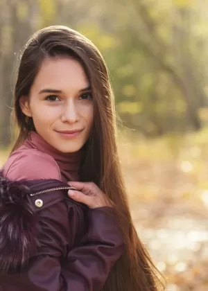 Симпатичная русская девушка Леона Миа ест мороженое в лесу в одежде