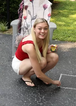 Молодая блондинка Эмбер Мур писает на подъездной дорожке, играя со своей киской