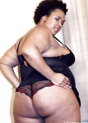 Зрелая негритянка жирная кошечка позирует для сольной съемки в нижнем белье и на каблуках