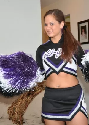 Симпатичная болельщица задирает юбку, чтобы показать свою сочную попку в черных стрингах