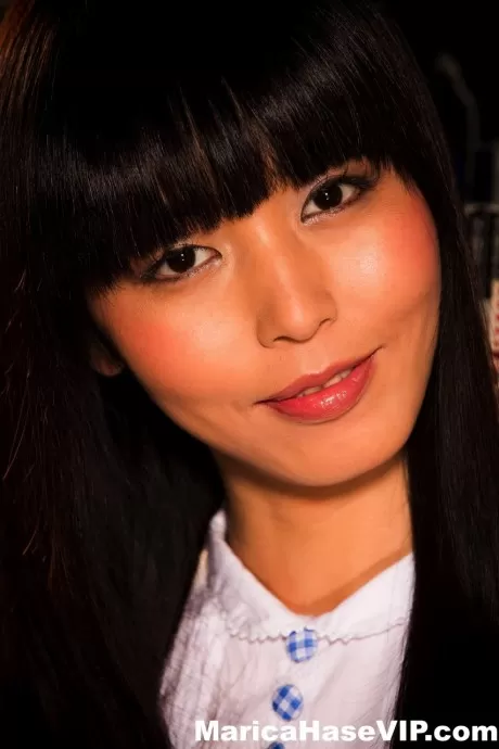 Японка Марика Хасэ показывает свои трусики, беря книгу из стопки