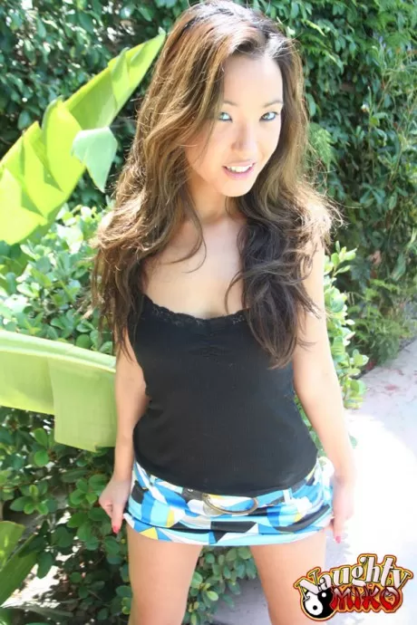 Симпатичная азиатка Мико надевает мини поверх черных трусиков на съемке в саду SFW