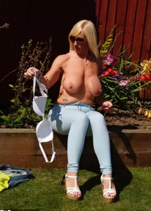 Busty blonde Melody lounges topless in the yard flaunting hot mature tits