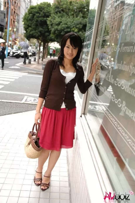 Японская красавица Мио Канна прогуливается по центру города в юбке длиной до колен