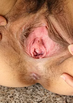 Одетая в чулки и униформу азиатка-новичок раздвигает волосатую пизду на кухне