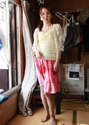 Рыжеволосая японка Чика Сасаки раздевается до коричневых чулок перед окном