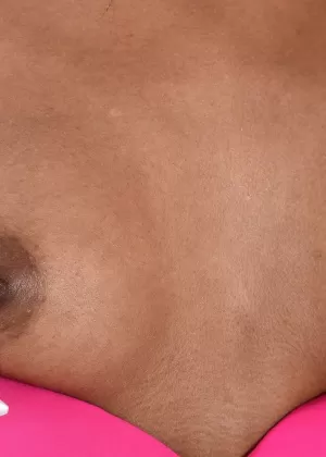 Чернокожая девушка Амилиан Куш снимает свой розовый лифчик и трусики, чтобы позировать обнаженной