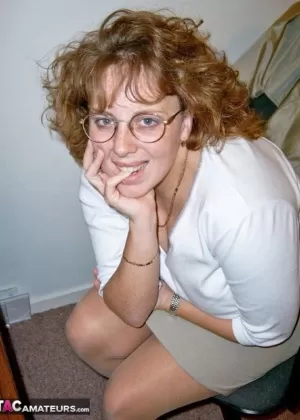 Зрелая леди демонстрирует свои красивые сиськи, надев сексуальные чулки и туфли на каблуках