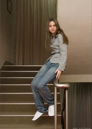 Молодая брюнетка милашка практикует свои соблазнительные позы в обтягивающих джинсах