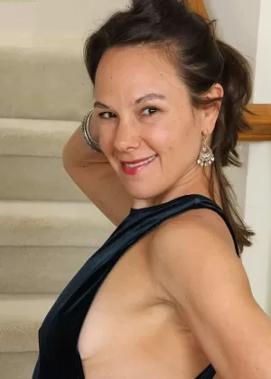 Блондинка средних лет раздевается до чулок во время работы по дому