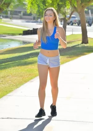 Спортивная блондинка в штанах для йоги делает растяжку тренируется и бегает трусцой голышом