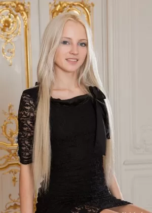 Симпатичная блондинка Алиша снимает свое черное платье для позирования обнаженной на скамейке