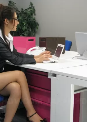 Japanese secretary Julia Nanase shows nylon clad legs in a business skirt