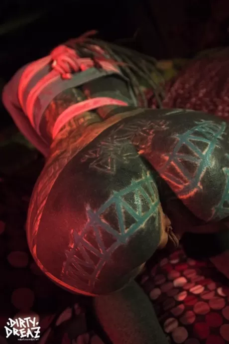 Сильно татуированная женщина связана розовой веревкой в очках на