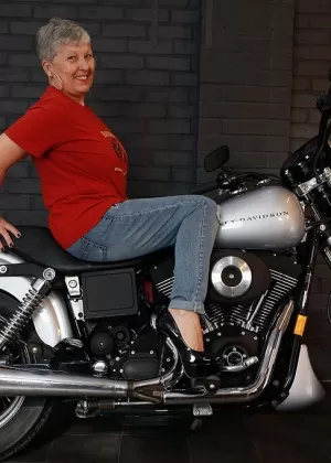 Старая любительница Савана моделирует нижнее белье на мотоцикле Harley Davidson