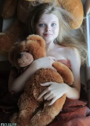 Крошечная подросток Киса принимает соблазнительные обнаженные позы, держа в руках плюшевого мишку