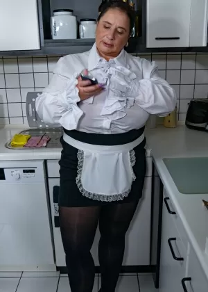 Зрелая толстушки обнажает свои массивные сиськи, прежде чем поиграться со своей киской на кухне