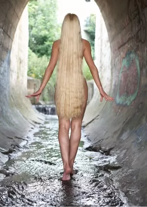 Тощая голая подросток Дезире с длинными распущенными волосами растягивается голышом в ручье