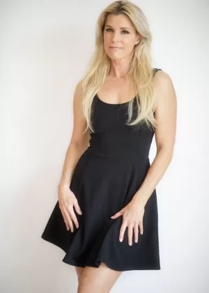 Сольная модель Индия Саммер снимает черное платье и трусики, чтобы позировать обнаженной