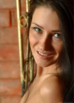 Сольная модель с длинными черными волосами позирует сама по себе полностью обнаженной