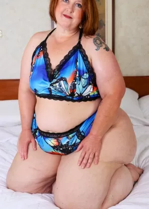 Тучная рыжеволосая Золотая бомба рекламирует свою массивную задницу в бикини