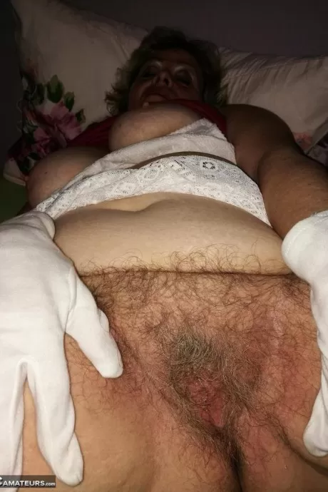 Возбужденная Нэн Каро стягивает свои колготки, чтобы показать свой куст в белых перчатках