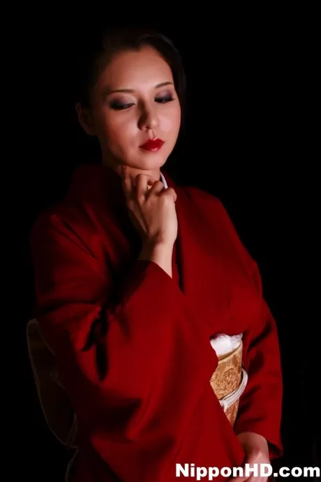 Японская женщина щеголяет красными губами, изготовляя нож в традиционной одежде