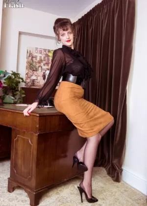 Длинноногая Кейт Энн позирует на столе, выставляя напоказ свои винтажные шелковые чулки