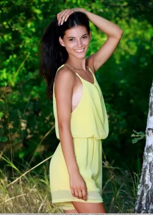 Симпатичная молоденькая Александрина обнажает свое загорелое тело у лиственного дерева